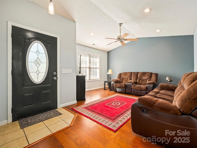 entrance foyer with wood-type flooring, lofted ceiling, ceiling fan, and a textured ceiling