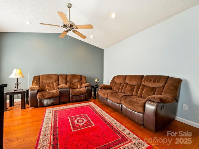 living room featuring vaulted ceiling, ceiling fan, and hardwood / wood-style floors