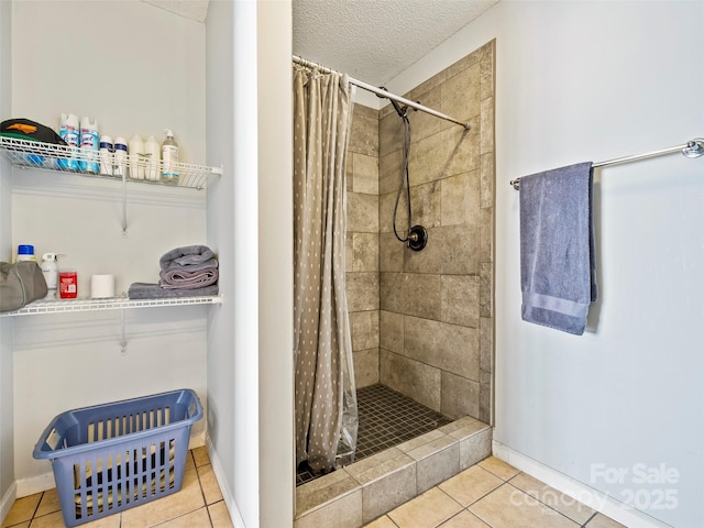 bathroom featuring curtained shower, tile patterned flooring, and a textured ceiling