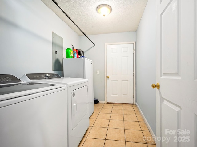 laundry room featuring light tile patterned floors, washing machine and clothes dryer, a textured ceiling, and electric panel