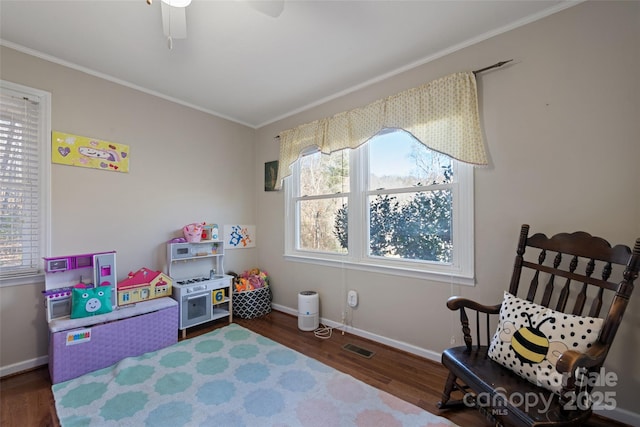 rec room featuring ornamental molding, ceiling fan, and dark hardwood / wood-style flooring