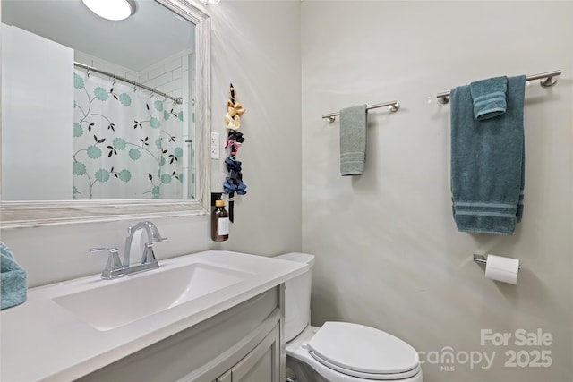 bathroom featuring a shower with curtain, vanity, and toilet