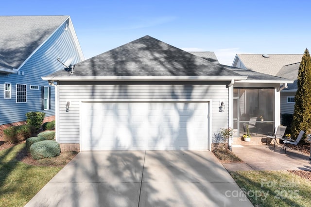 view of side of property with a garage, a sunroom, and a patio