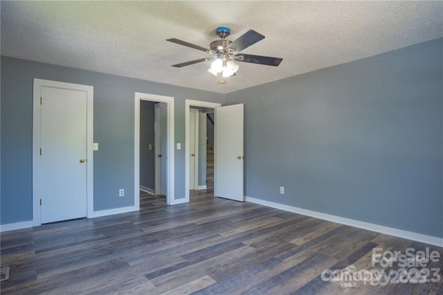 unfurnished bedroom with ceiling fan, dark hardwood / wood-style floors, and a textured ceiling