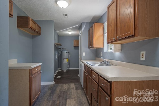 kitchen featuring sink, dark hardwood / wood-style floors, water heater, and a textured ceiling