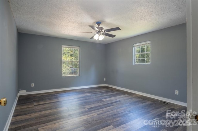 spare room with dark wood-type flooring, a textured ceiling, and ceiling fan