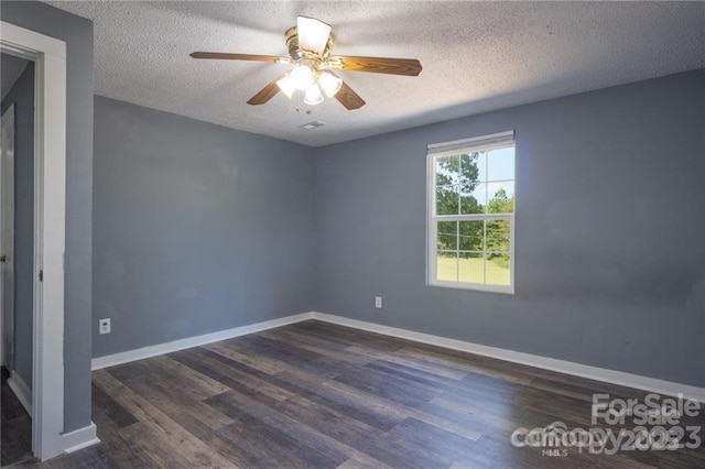 empty room with ceiling fan, dark hardwood / wood-style flooring, and a textured ceiling