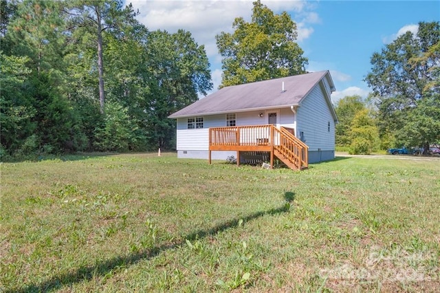 rear view of house featuring a yard and a deck