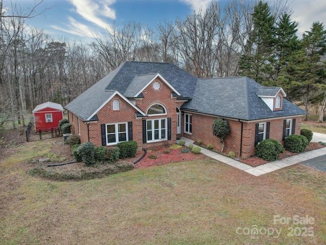 view of front of property with a storage shed and a front yard