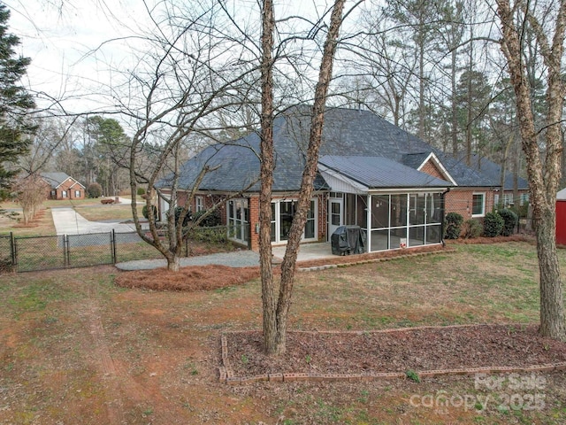 back of property featuring a yard and a sunroom