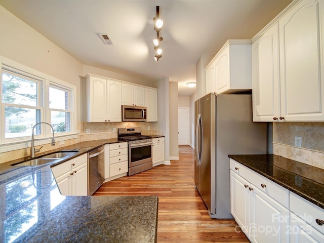 kitchen featuring appliances with stainless steel finishes, sink, and white cabinets