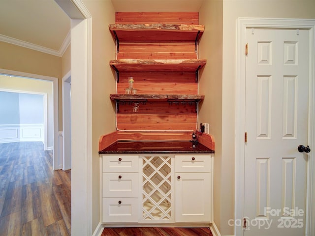 bar featuring white cabinetry, crown molding, and hardwood / wood-style floors