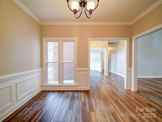 unfurnished room with a notable chandelier, ornamental molding, and dark hardwood / wood-style floors