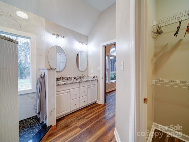 bathroom with hardwood / wood-style flooring, vanity, vaulted ceiling, and a healthy amount of sunlight