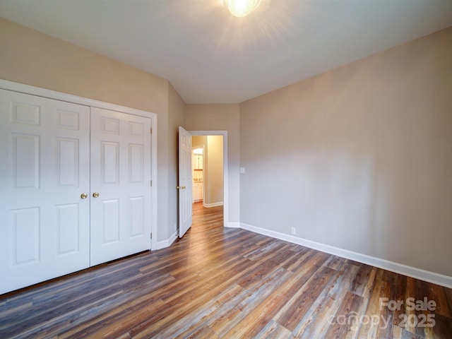 unfurnished bedroom featuring dark hardwood / wood-style floors and a closet