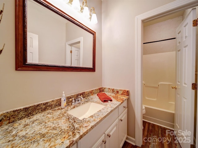 full bathroom featuring vanity, hardwood / wood-style floors, shower / washtub combination, and toilet