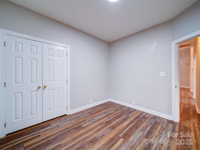 unfurnished bedroom featuring dark hardwood / wood-style floors and a closet