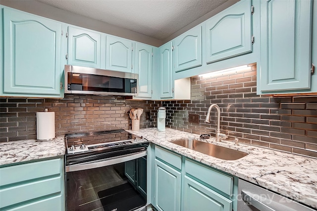 kitchen featuring sink, decorative backsplash, stainless steel appliances, and a textured ceiling