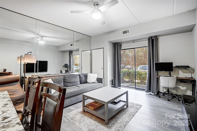 living room with light wood-type flooring and ceiling fan