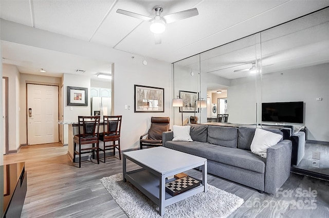 living room with wood-type flooring and ceiling fan