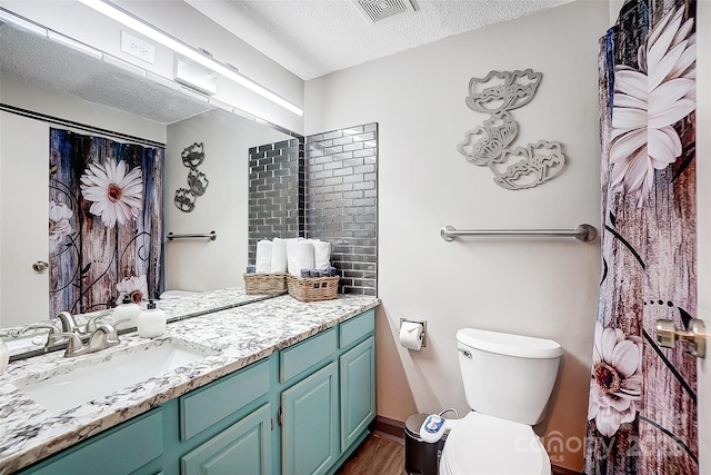 bathroom featuring vanity, toilet, wood-type flooring, and a textured ceiling