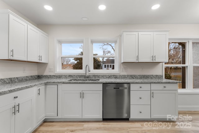 kitchen with sink, light stone counters, white cabinetry, dishwasher, and light hardwood / wood-style floors