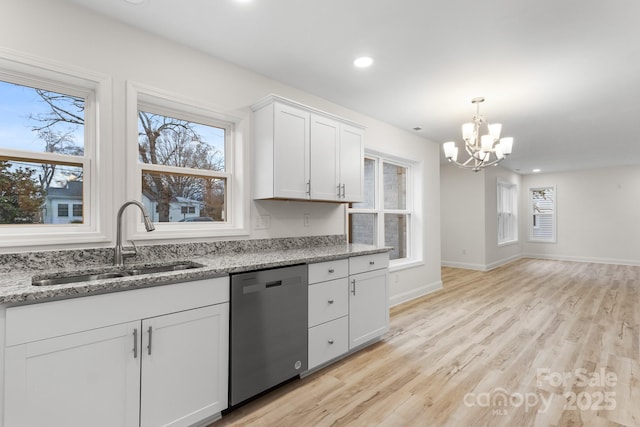 kitchen with white cabinetry, sink, stainless steel dishwasher, light stone countertops, and light wood-type flooring