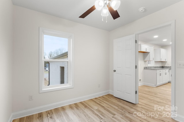 spare room featuring ceiling fan and light wood-type flooring