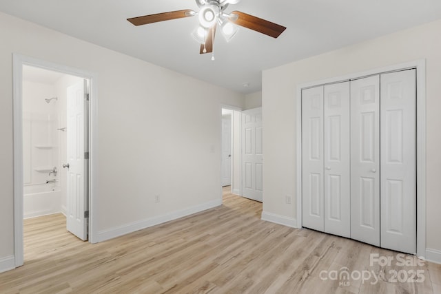 unfurnished bedroom with connected bathroom, light hardwood / wood-style flooring, a closet, and ceiling fan