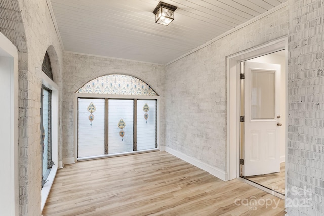 empty room featuring crown molding and light wood-type flooring