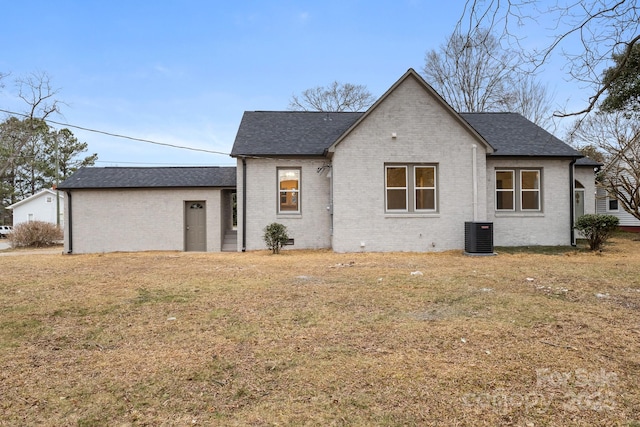 view of front of house with central AC and a front yard