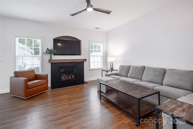 living room featuring ceiling fan, a healthy amount of sunlight, and dark hardwood / wood-style floors