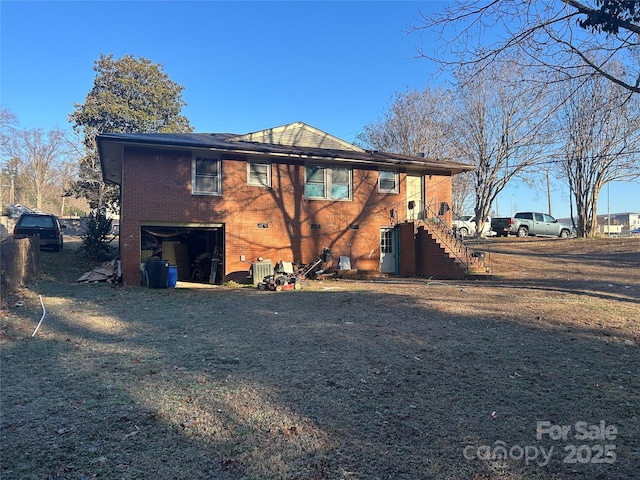 rear view of property featuring central AC unit and a garage