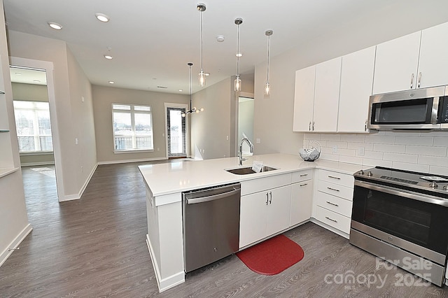 3630 N Davidson St, Charlotte, NC 28205 - kitchen with sink, dark wood-type flooring, stainless steel appliances, tasteful backsplash, and kitchen peninsula