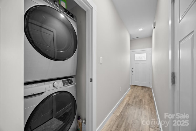 washroom featuring stacked washer and clothes dryer and light wood-type flooring