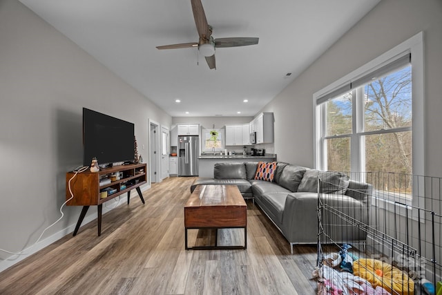 living room featuring ceiling fan and light hardwood / wood-style floors