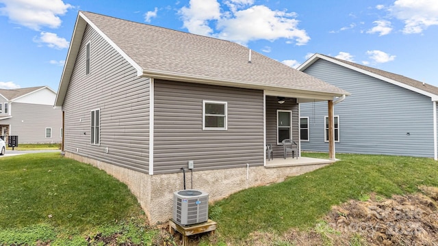 rear view of house featuring a patio, a yard, and central AC unit