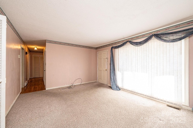 unfurnished room with crown molding, carpet, and a textured ceiling