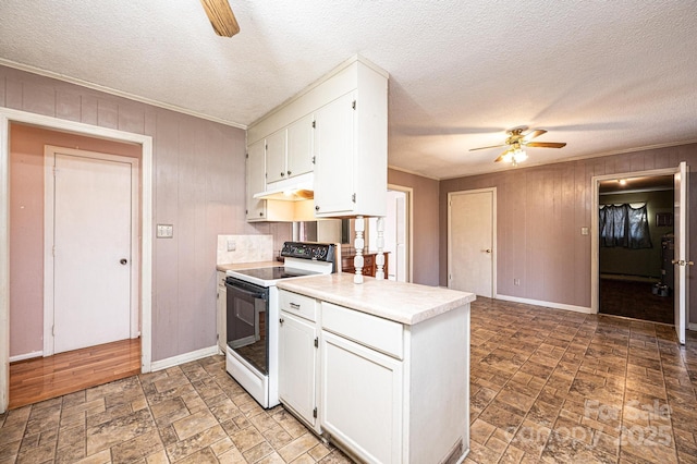 kitchen with white cabinetry, ornamental molding, wooden walls, ceiling fan, and white range with electric stovetop