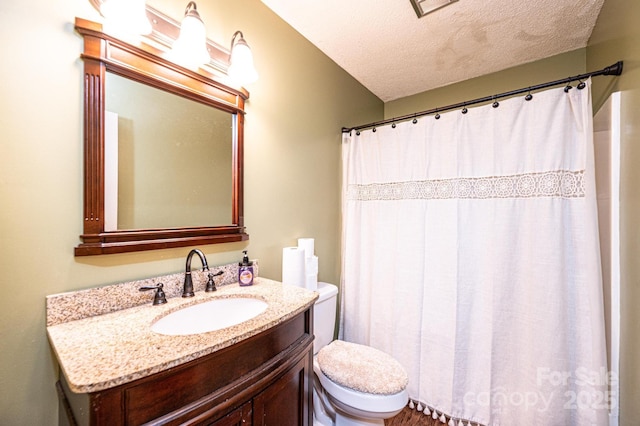 bathroom featuring vanity, toilet, and a textured ceiling