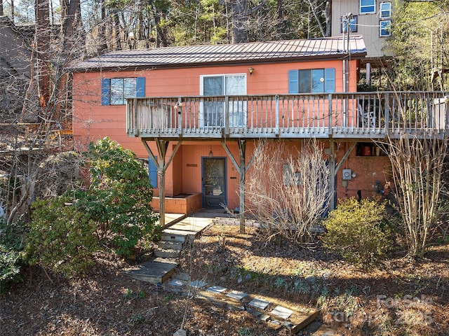 rear view of property with metal roof and a standing seam roof