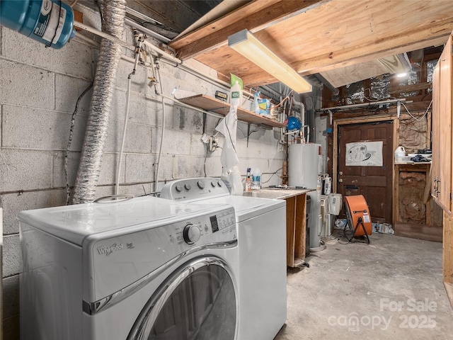 washroom featuring water heater, laundry area, independent washer and dryer, and concrete block wall