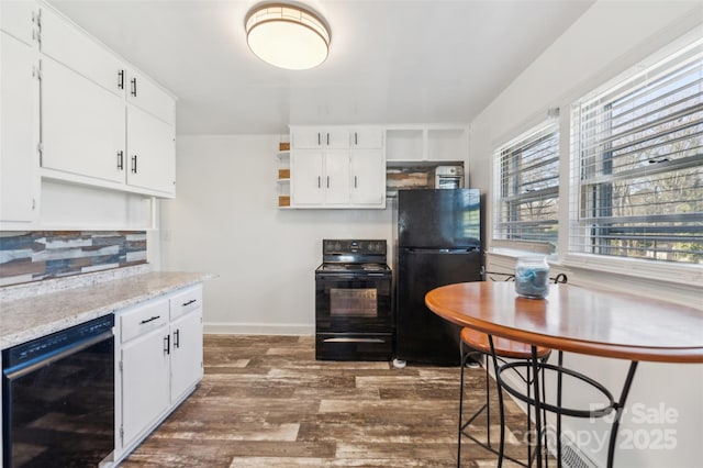 kitchen featuring dark hardwood / wood-style flooring, backsplash, black appliances, and white cabinets