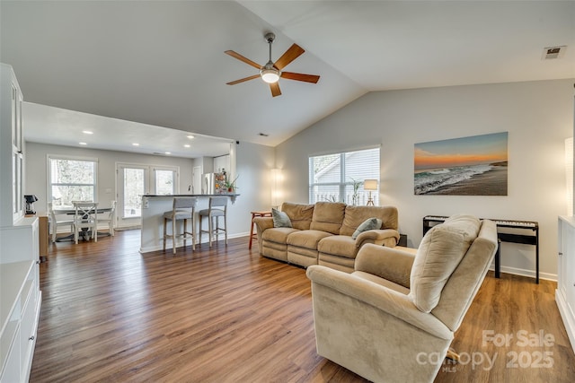 living room with hardwood / wood-style flooring, lofted ceiling, and a wealth of natural light