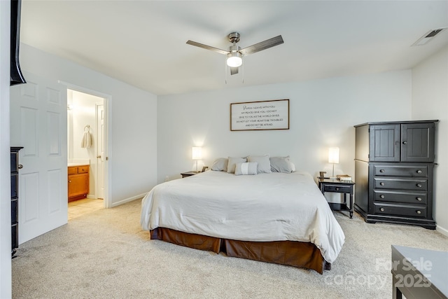 bedroom featuring connected bathroom, light colored carpet, and ceiling fan