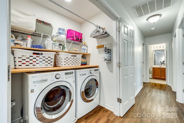 laundry room with wood-type flooring and washing machine and clothes dryer