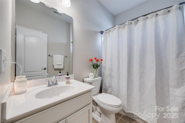 bathroom with vanity, tile patterned floors, toilet, and walk in shower