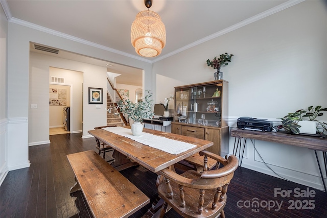 dining room with ornamental molding and dark hardwood / wood-style floors