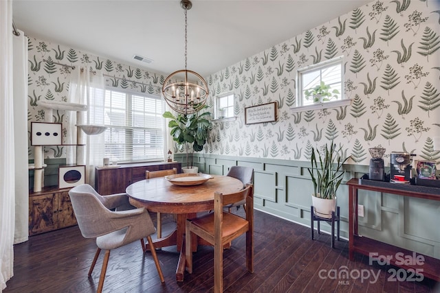 dining area with a chandelier, a wealth of natural light, and dark hardwood / wood-style flooring