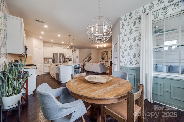 dining area featuring an inviting chandelier and dark wood-type flooring